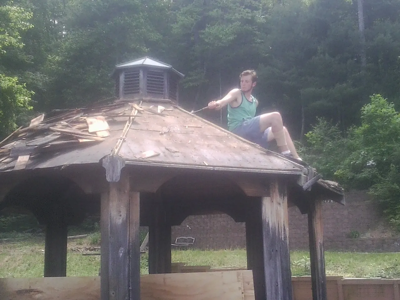 Tearing the old roof off a wooden gazebo before new shakes in Quinault