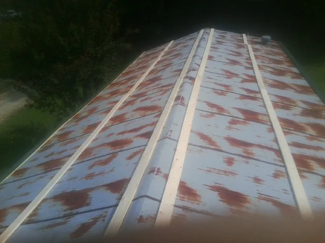 Rusted metal roof panels with new wood purlins before replacement — Storm Damage Roof Repair in Quinault by Roofing Brothers
